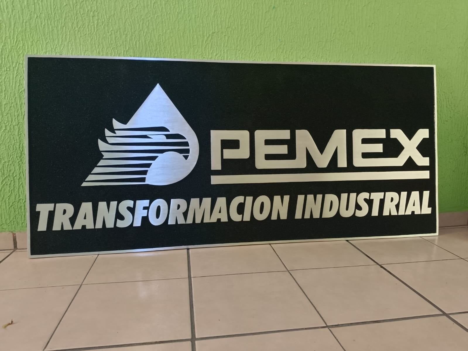 Placa de aluminio fundido de Pemex Transformación Industrial, con logotipo y letras pulidos en relieve sobre fondo oscuro