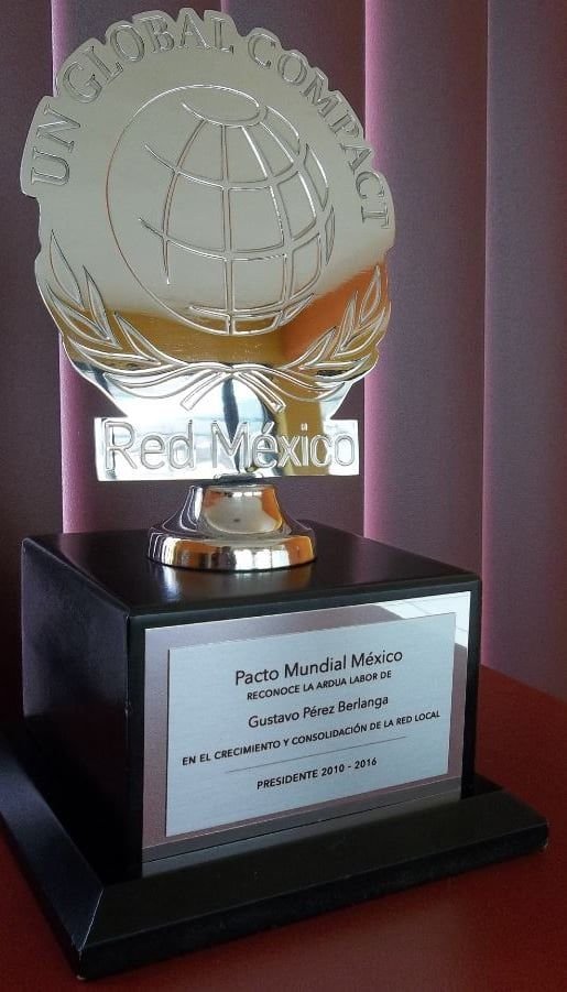 Trofeo Pacto Mundial México con el emblema de UN Global Compact en latón dorado y logotipo niquelado sobre base de madera negra